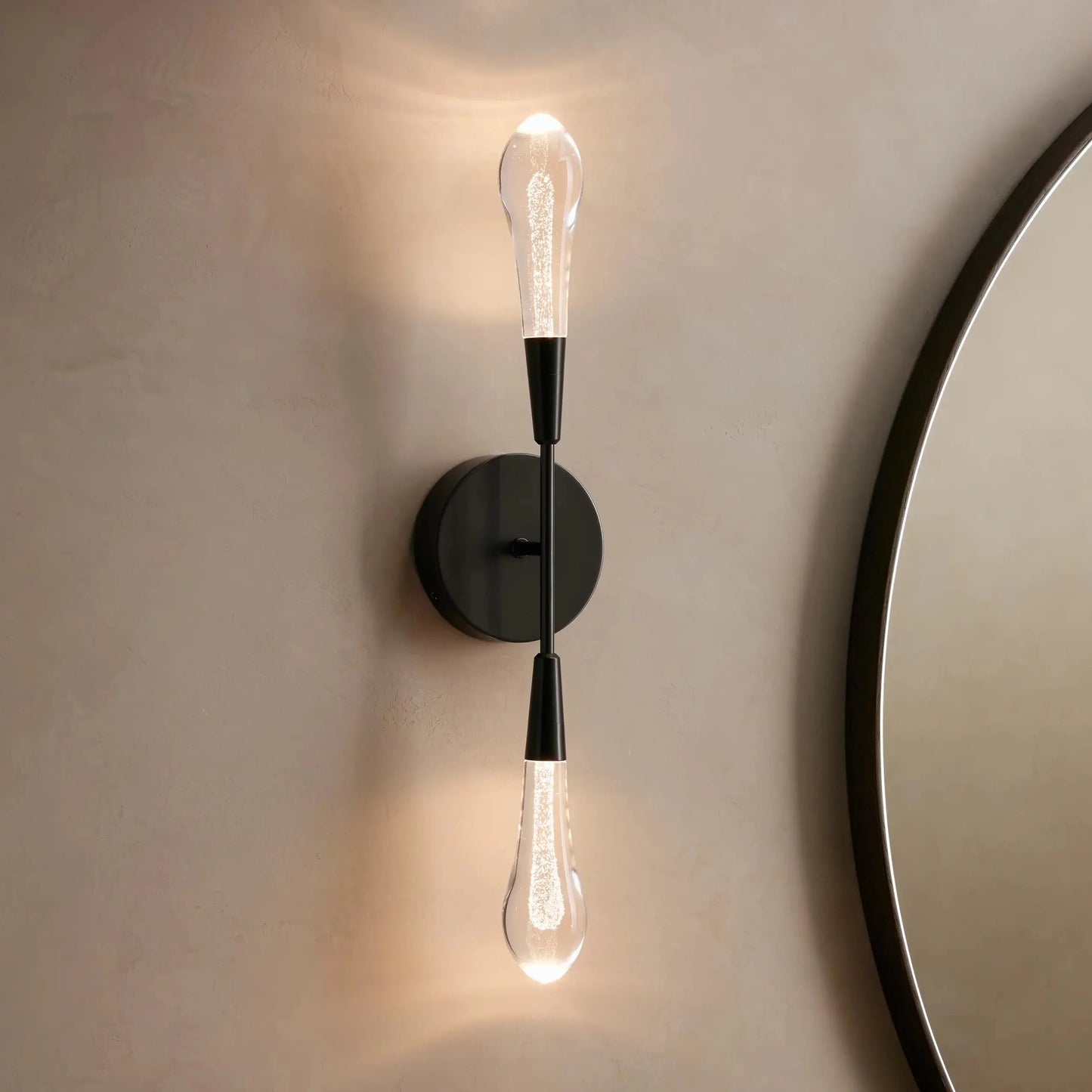Modern wall sconce with two light bulbs on a neutral wall.